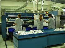 A feeder where linen is placed and which takes the linen to the ironer and folder