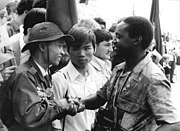 越共的一位青年代表向一个与苏联人结伴而行，身份不明的非洲国家的年轻人致意。 他们俩都参加了由德国自由青年组织的，在东德举行的1973年世界青年会议。