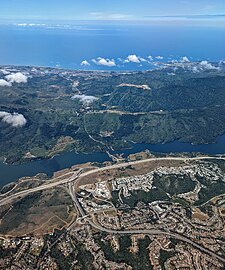 Aerial view directed west showing interchange with SR 92; Crystal Springs Reservoir runs north-south parallel to I-280 through the middle of the photograph