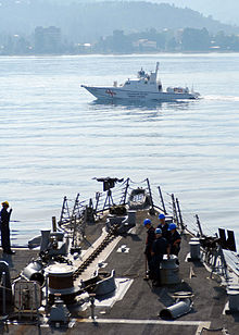 Smaller military boat passing a larger one
