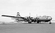 Photo en noir et blanc montrant une vue de trois-quarts avant d'un bombardier à hélices, avec le fuselage gris.