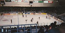 men on skates playing ice hockey in an arena