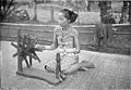 Dayak girl at spinning wheel, c 1900