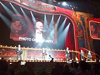 Monty Python on stage with an image of John Cleese projected on a big screen