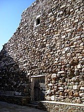 Ruines d'un haut mur en pierres.