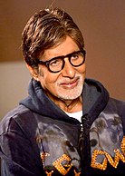 Amitabh Bachchan is smiling at the camera