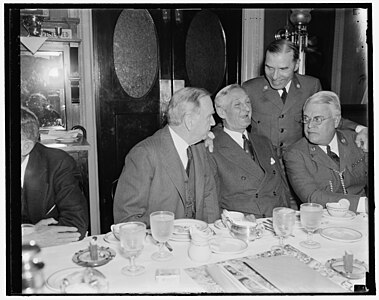 Former Boy Scouts get together. Washington, D.C., May 21. Boy Scouts of yesteryear, whose path led to the Nation's legislative halls, got together this morning for an old-fashioned breakfast of ham and eggs, the breakfast was held at the Senate restaurant, the occasion of the breakfast was a discussion of the Boy Scout Jamboree to be held in Washington, left to right: Sec. of Commerce Daniel Roper; Sen. William Gibbs McAdoo, D. of Calif.; James L. West, Pres. of the National Boy Scouts; and standing is Rep. Sol Bloom, New York[9]