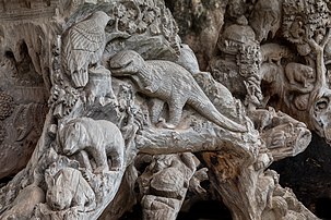 Tronc d'arbre sculpté avec des reliefs représentant un dinosaure, un oiseau, un ours, un lapin et une tortue, dans le jardin du Vat Phra Kèo, à Vientiane, au Laos. (définition réelle 5 995 × 3 997)