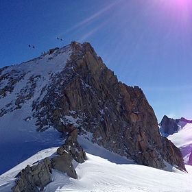 Le Gros Rognon depuis le nord-ouest avec deux trains de cabines de la télécabine Panoramic Mont-Blanc à proximité du sommet.