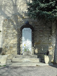 Le monument aux morts : une simple stèle, surmontée d’un casque Adrian, placée en avant de la mairie. Un manque a été laissé dans l’enduit de la mairie, en forme d’arche, et la met en valeur