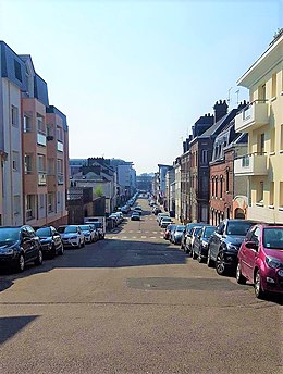 Cliché numérique couleur. Rue bordée d'immeubles d'habitation de trois étages du XXe siècle en enfilade.