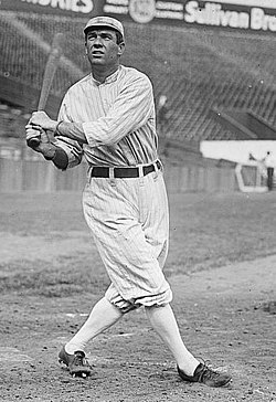 A batter in a pin-striped uniform after swinging at a ball