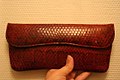 Clutch with fold-over closure, made of red snakeskin