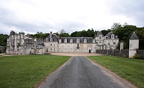 Photographie en couleurs d'un long bâtiment terminé par deux pavillons.