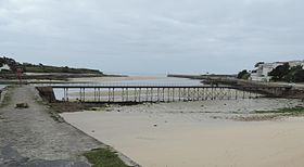 La passerelle des Capucins et le chenal du port d'Audierne à marée basse.