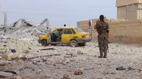 An SDF fighter stands in a destroyed area of Tabqa