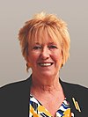 Official Portrait of Christine Grahame MSP. She is smiling, with short blonde hair and a colourful top. There is a grey-ish background.