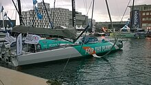 Vu de trois quarts arrière, bateau blanc et vert amarré au ponton.