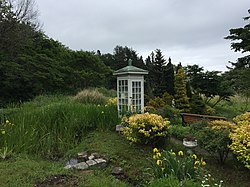Photograph of a white telephone booth in a garden
