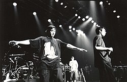 Three men singing into microphones