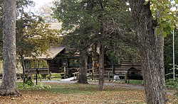 Log house partially screened by trees