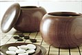 Image 2An example of single-convex stones and Go Seigen bowls. These particular stones are made of Yunzi material, and the bowls of jujube wood. (from Go (game))