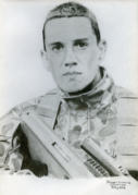Hand-drawn pencil portrait of a soldier holding an assault rifle. He has cropped hair and is facing the viewer.