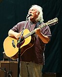 David Crosby, 2006, using a 12-string acoustic guitar patterned after its Martin equivalent (in this case, a 12-fret, round shouldered design)