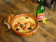 Fabada asturiana, a rich Spanish bean stew, as typically served with crusty bread and Asturian cider