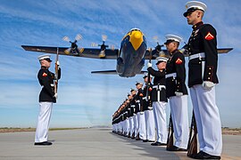 Un avion de transport Hercules C-130T en vol de démonstration avec l'escadrille Blue Angels passant au-dessus de Marines.