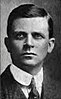 Black-and-white head-and-shoulders portrait of a clean shaven man with dark hair in an early 20th century business suit