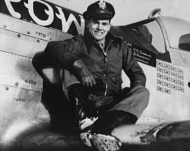 Le capitaine Clarence E. Jr. « Bud » Anderson, as du 357th Fighter Group, est assis sur l’aile de son P-51 Mustang (B6-S, numéro de série 44-14450) surnommé « Old Crow ».