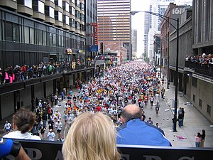 A massa de corredores atravessa a Grand Avenue no centro de Chicago.