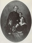 A black-and-white photograph of a mother and father posed with their their son and two daughters