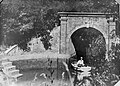 A man in a boat by Swan's Arch circa 1920. The tributary stream pictured here was redirected to flow through a pipe.[17]