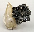 附在黑色闪锌矿晶簇上的棕褐色方解石晶体