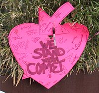 Heart-shaped sign reading "We stand with Comet"