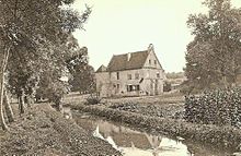 Bâtiment massif entouré d'arbres et proche d'une rivière