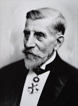 Portrait d'Henri Duhem portant la cravate de commandeur de la Légion d’honneur, photographié en 1932 par Edouard Baron (1880-1950)[24].