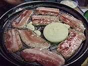 Samgyeopsal is a popular Korean dish that is commonly served as an evening meal. It consists of thick, fatty slices of pork belly meat.