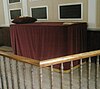 A simple, Low Church-style altar in St John the Evangelist's Church, Chichester, covered with a deep red altar cloth and set behind wooden railings