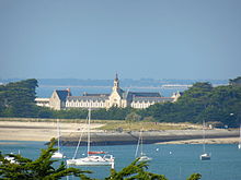 vue en couleur d'un bâtiment allongé en arrière-plan d'un bras de mer.