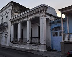 Photograph of the Zaldo de Nebot Residence, a one story building with a prominent cornice and pillared front in an urban setting