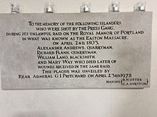 Photograph of a memorial plaque in a church, topped with candles