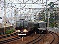 JR神戸線の複々線区間を走行する321系（左）と223系（右）。左側2線が電車線で通勤形を、右側2線が列車線で近郊形を使用する。