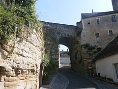 Photographie en couleurs d'une arche en pierre enjambant une rue encaissée