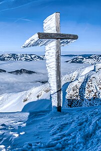 De la glace givrée, acccumulée par le vent, s'est formée sur la croix sommitale du Fronalpstock (canton de Schwytz), dans les Alpes suisses. (définition réelle 3 440 × 5 160)