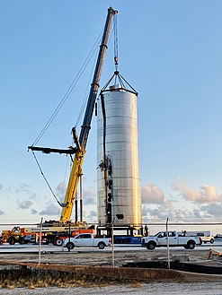 Photograph of a crane lifting a steel body