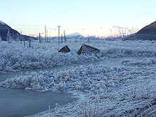 An image of a broken down house in the snow