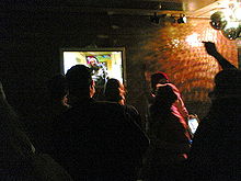 Dark nightclub with illuminated television screen and disco balls